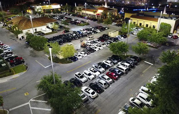 An aerial view of the outdoor LED lighting at The Palms Town Country building and parking lot at night